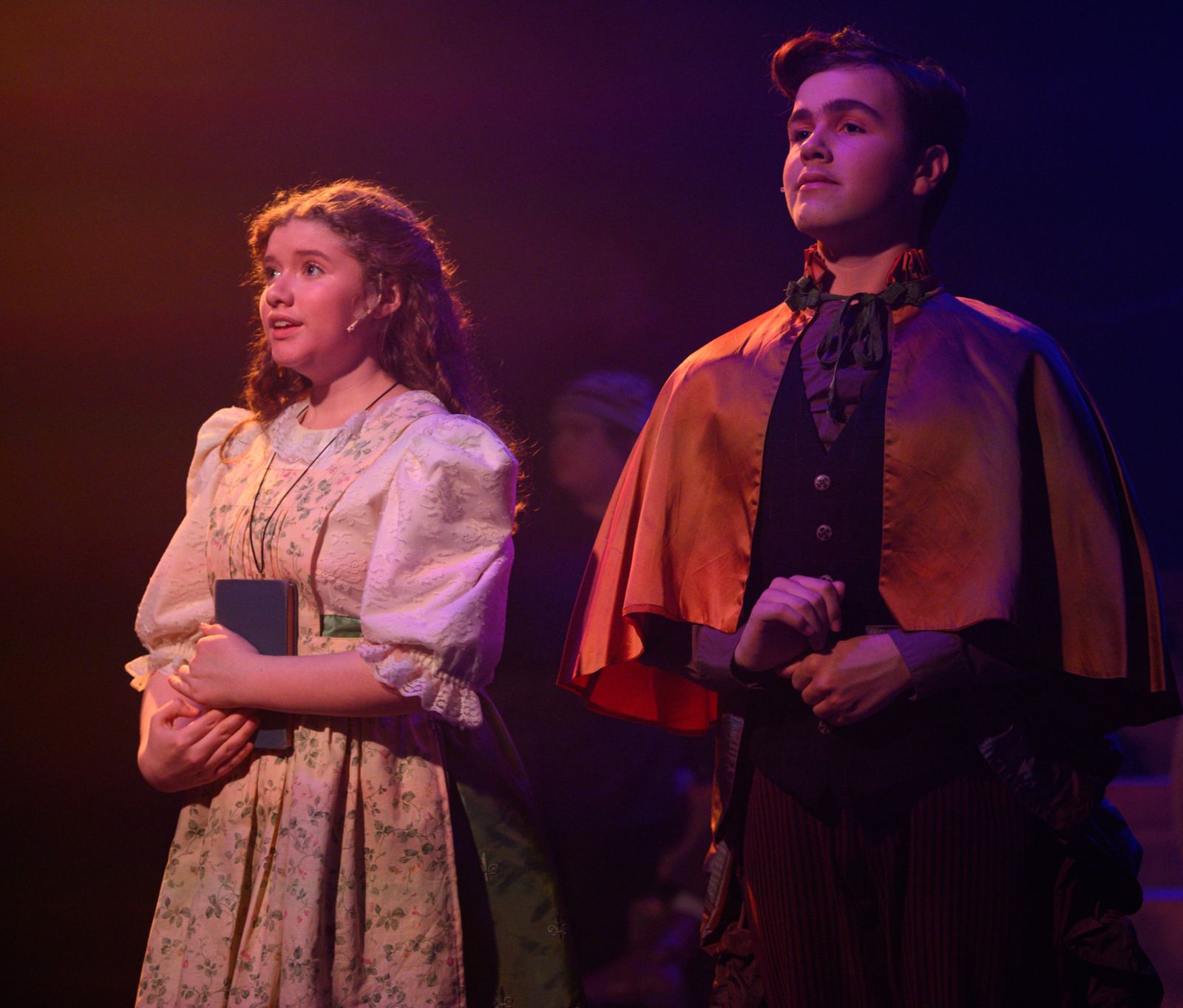 Parker Pitt as Molly Aster holding a book beside Betty Bumbrake in Peter and the Starcatcher at Valley Youth Theatre