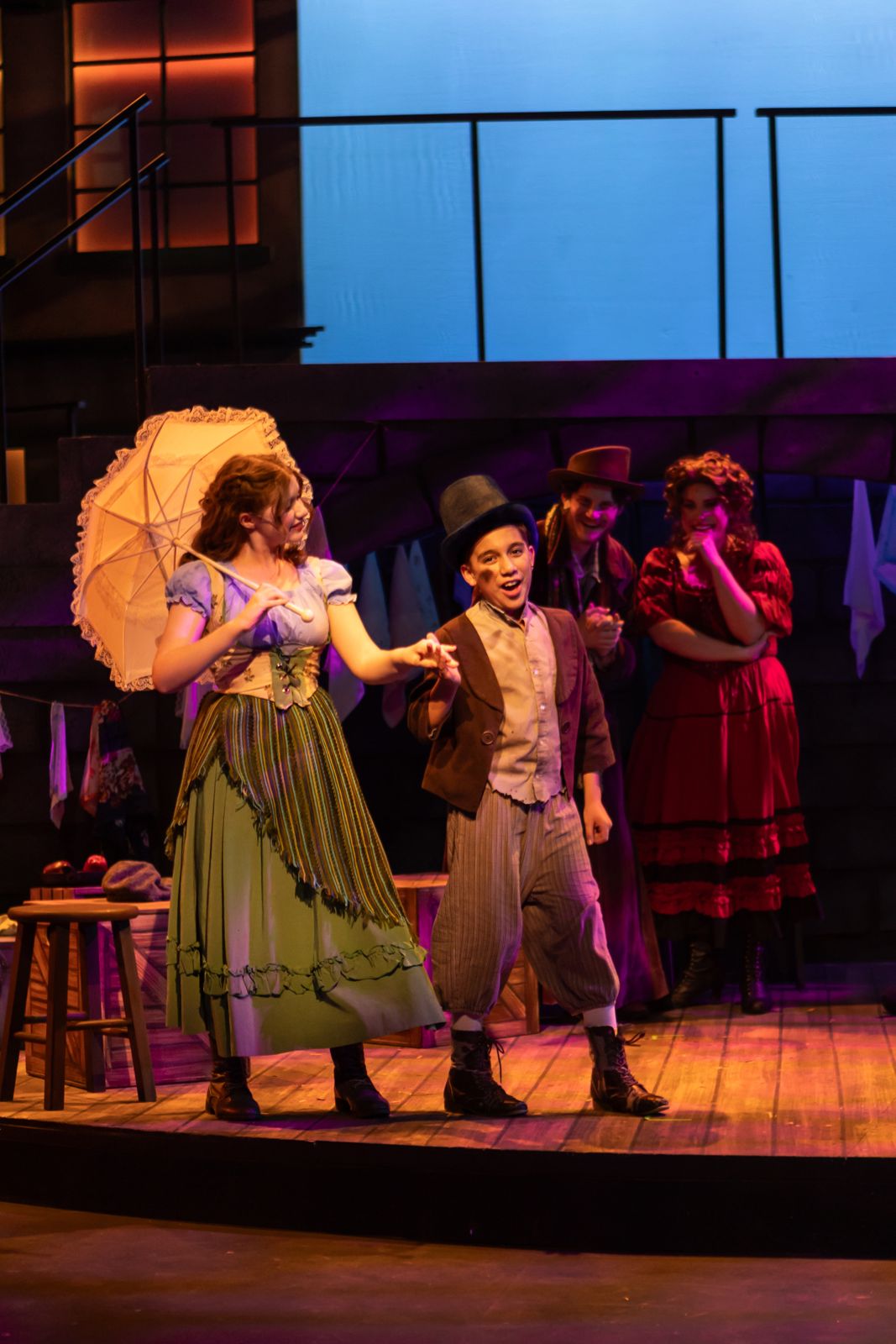 Parker Pitt as Bet holding a parasol beside the Artful Dodger in Oliver! at TheaterWorks