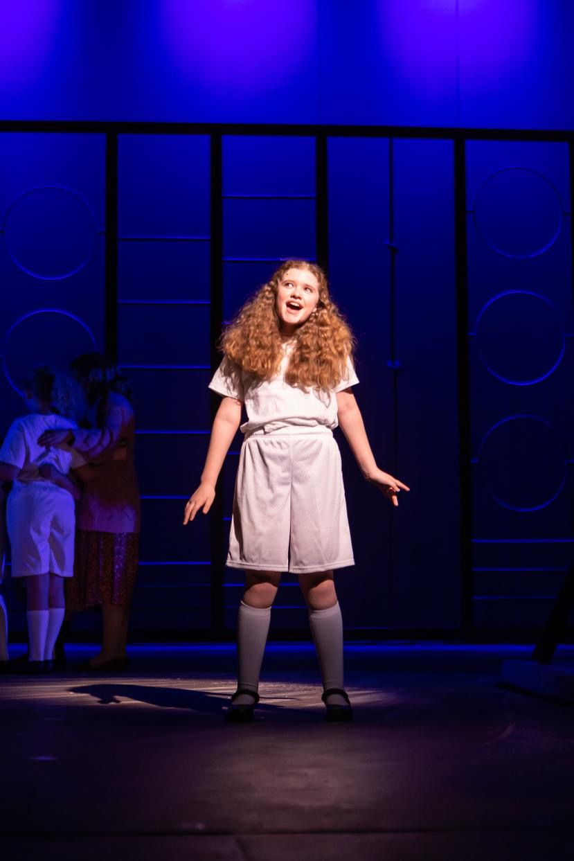 Parker Pitt as Matilda singing alone onstage in Matilda the Musical at TheaterWorks