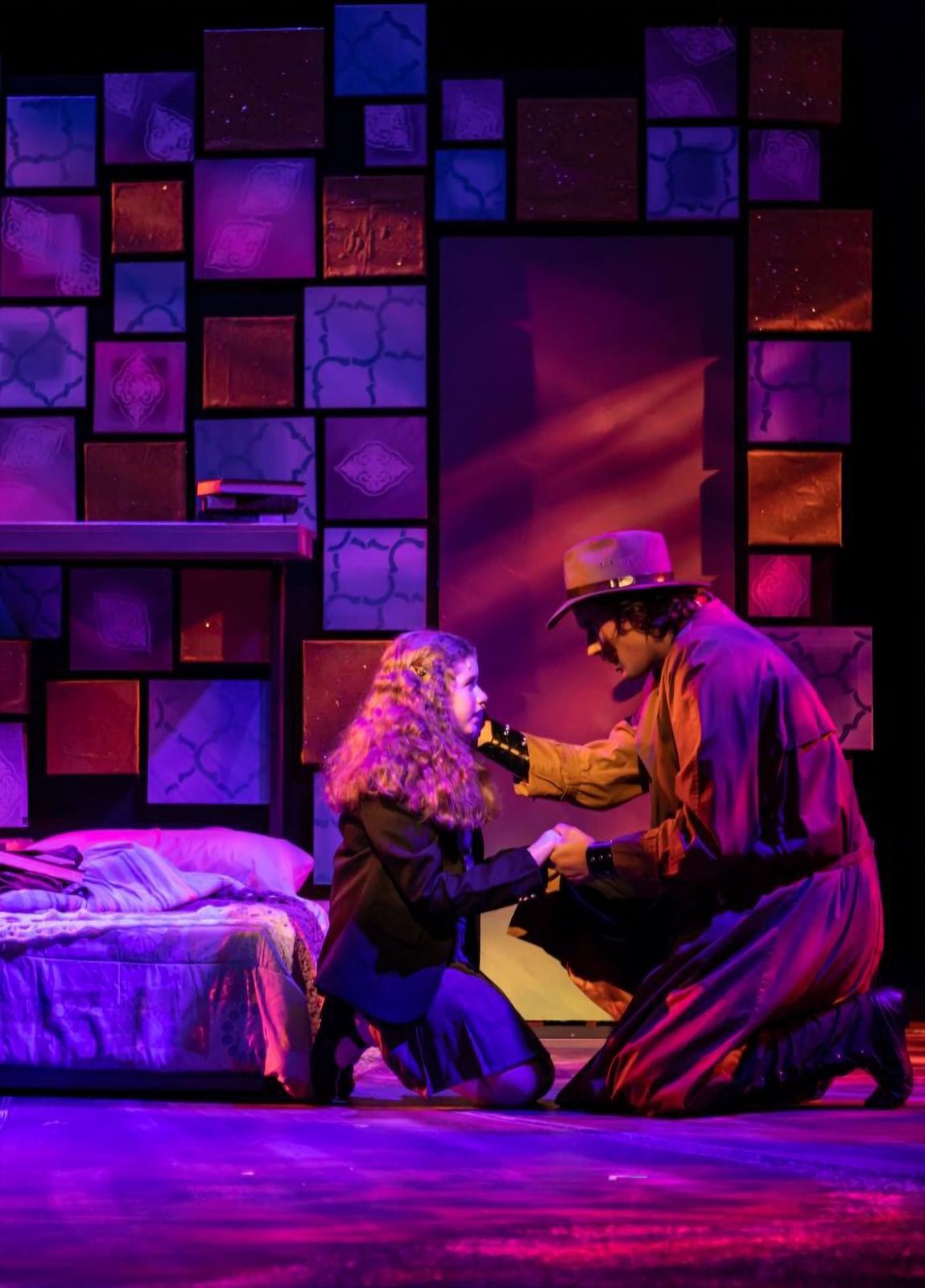 Parker Pitt as Matilda kneeling with the Escapologist in Matilda the Musical at TheaterWorks