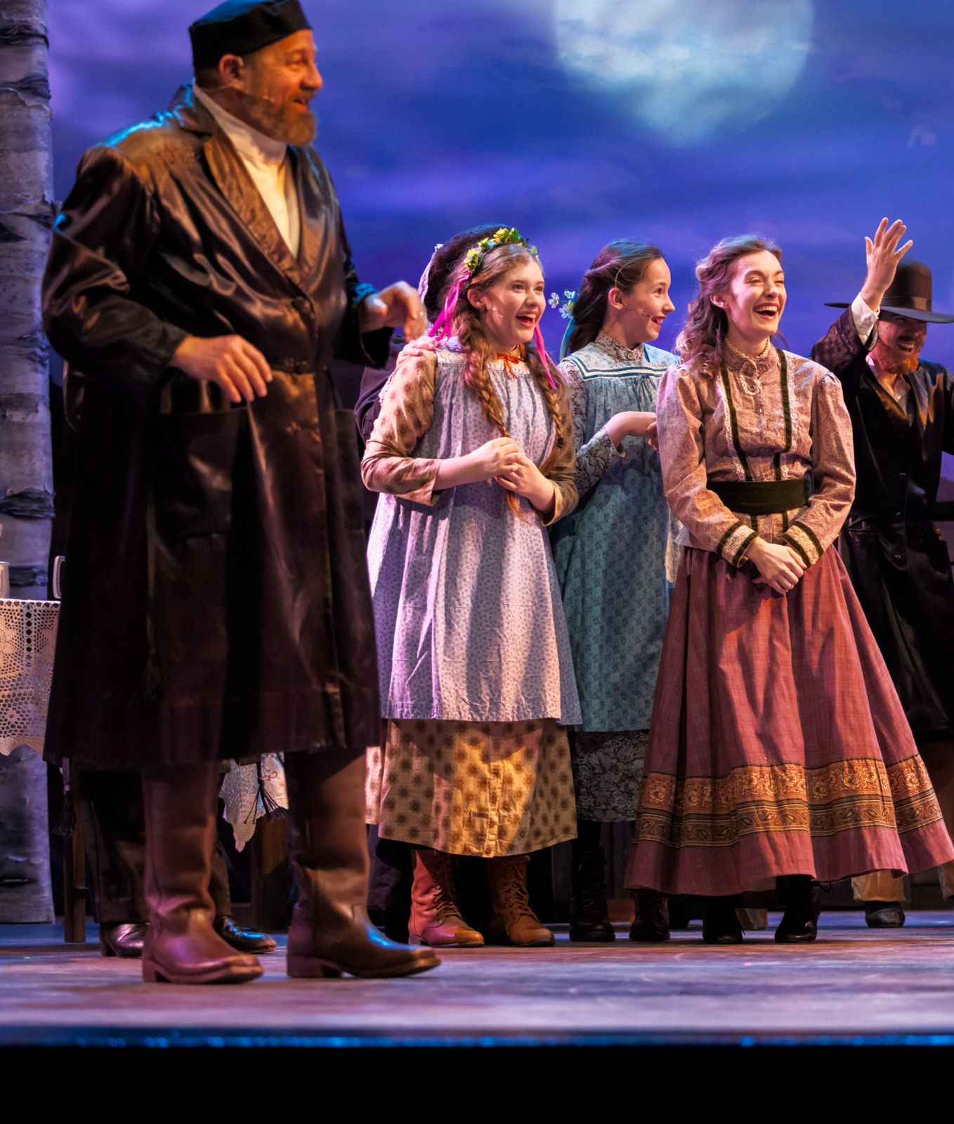 Parker Pitt as Bielke laughing at the wedding with Chava and Tevye in Fiddler on the Roof at The Phoenix Theatre Company