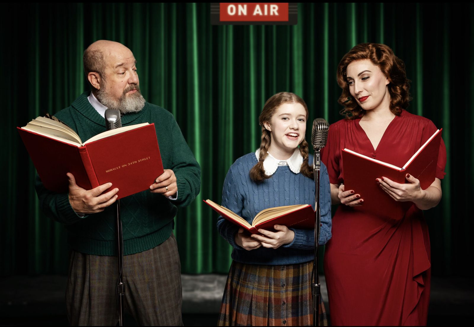 Parker Pitt as Gracie DeMarco reading a radio script with Kris Kringle and Doris Walker in Miracle on 34th Street: A Live Musical Radio Show at The Phoenix Theatre Company