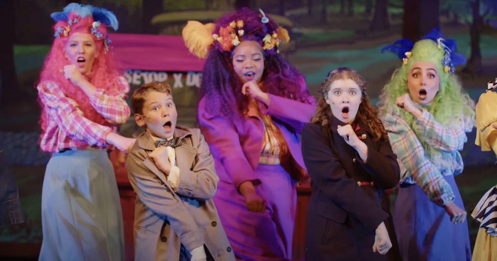 Parker Pitt as Jane Banks in a dark coat dancing with the company in Mary Poppins at TheaterWorks